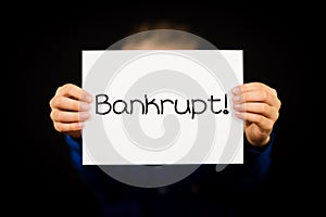 Child holding Bankrupt sign