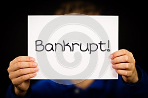 Child holding Bankrupt sign