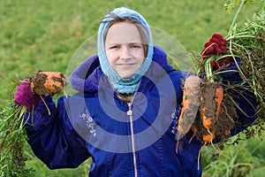 Child holding carrots.