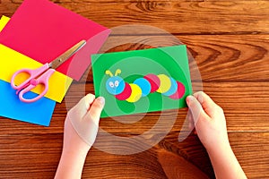 Child holding a caterpillar card. Summer paper crafts