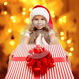 Child holding Christmas gift box in hand.