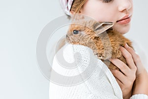 Child holding cute furry rabbit isolated on white