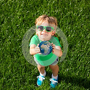 Child holding Earth planet in hands. Elements of this image furnished by NASA