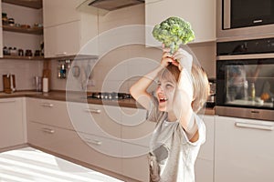 Child holding green broccoli.  Healthy  food concept. Child nutrition. Fresh vegetables in the hands of a cheerful boy child