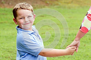 Child holding hands with parent while going for walk