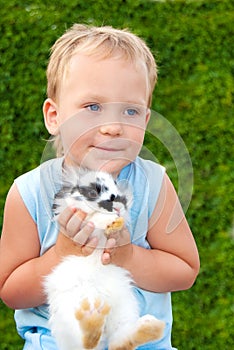 Child holding on hands of a small rabbit