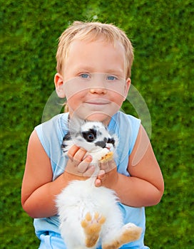 Child holding on hands of a small rabbit