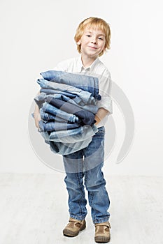 Child holding jeans stack. Kids clothing fashion photo