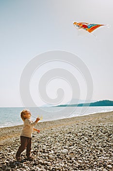 Child holding kite flying playing outdoor on beach summer holidays travel lifestyle