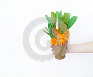 The child is holding a knitted carrot in his hand. Easter rabbit. Child`s hand.