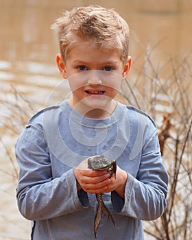 Child holding a large bullfrog