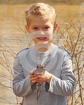 Child holding a large bullfrog