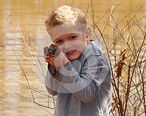 Child holding a large bullfrog