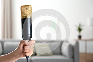 Child holding microphone on blurred background, closeup