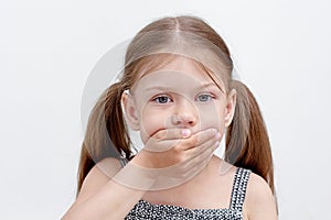 Child holding palm on mouth photo