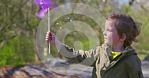 Child Holding Purple Pinwheel Outdoors