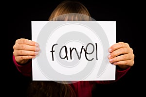 Child holding sign with Danish word Farvel - Bye