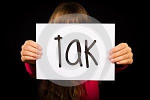 Child holding sign with Danish word Tak - Thank You