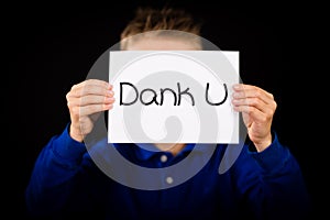 Child holding sign with Dutch words Dank U - Thank You