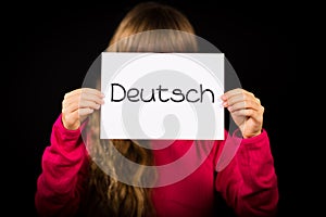 Child holding sign with German word Deutsch - German in English photo