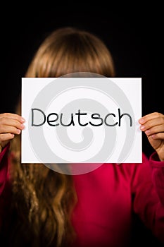 Child holding sign with German word Deutsch - German in English