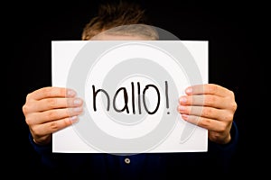 Child holding sign with German word Hallo - Hello in English