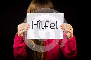 Child holding sign with German word Hilfe - Help photo