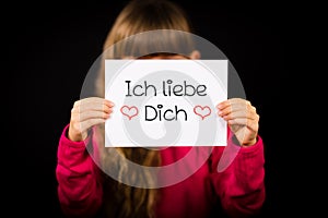 Child holding sign with German words Ich liebe Dich - I Love You