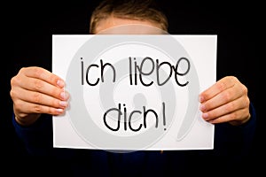Child holding sign with German words Ich liebe Dich - I Love You photo