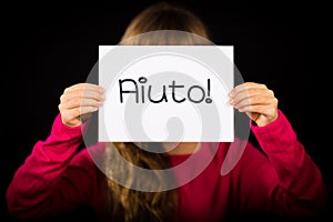 Child holding sign with Italian word Aiuto - Help photo