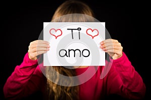 Child holding sign with Italian words Ti Amo - I Love You photo