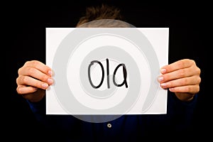 Child holding sign with Portuguese word Ola - Hello