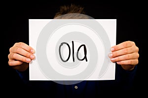 Child holding sign with Portuguese word Ola - Hello