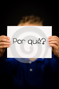 Child holding sign with Portuguese word Por Que - Why photo