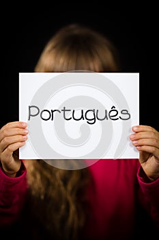 Child holding sign with Portuguese word Portugues - Portuguese i photo