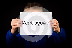 Child holding sign with Portuguese word Portugues - Portuguese i