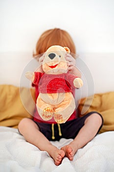 A child is holding a teddy bear