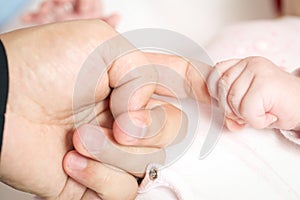 Child holding on to father's hand