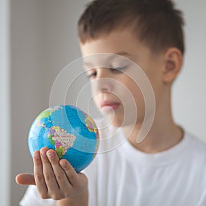 Child holding toy globus in his hand photo