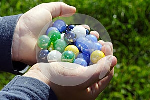 Child holding two hands full of marbles