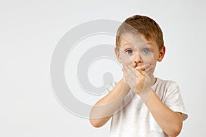 Child holds back the emotion of fear by covering his mouth with his hands