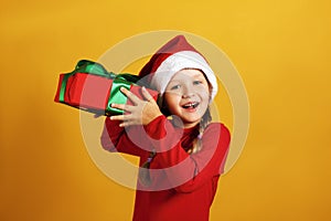 The child holds a box with a gift. Happy little girl with christmas present