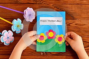 Child holds a card in his hand. Happy mother's day. A bouquet of flowers. Children's crafts for mother's day