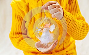 Child holds a Christmas decor and gifts on a white background. Selective focus.