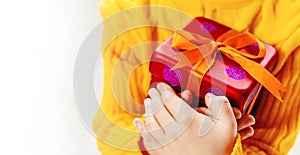 Child holds a Christmas decor and gifts on a white background. Selective focus.