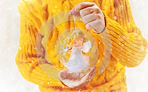 Child holds a Christmas decor and gifts on a white background. Selective focus