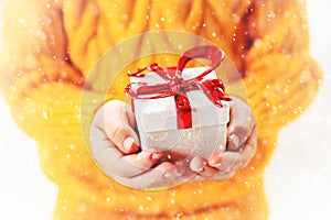 Child holds a Christmas decor and gifts on a white background. Selective focus