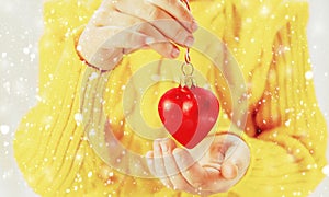 Child holds a Christmas decor and gifts on a white background. Selective focus