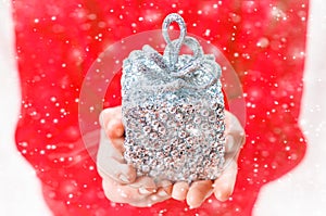 Child holds a Christmas decor and gifts on a white background. Selective focus