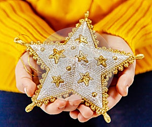 Child holds a Christmas decor and gifts on a white background. Selective focus.